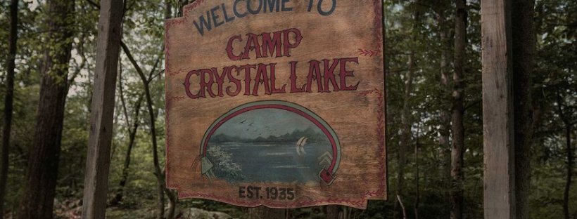 An image showing a sign that reads Crystal Lake hanging in the woods.